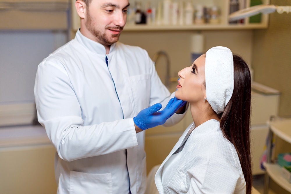 Donde me puedo hacer una rinoplastia: doctor examina a pciente femenina