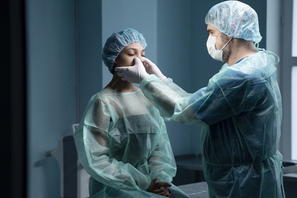 Cirujano revisa nariz de paciente para rinoplastia nariz de bola.-