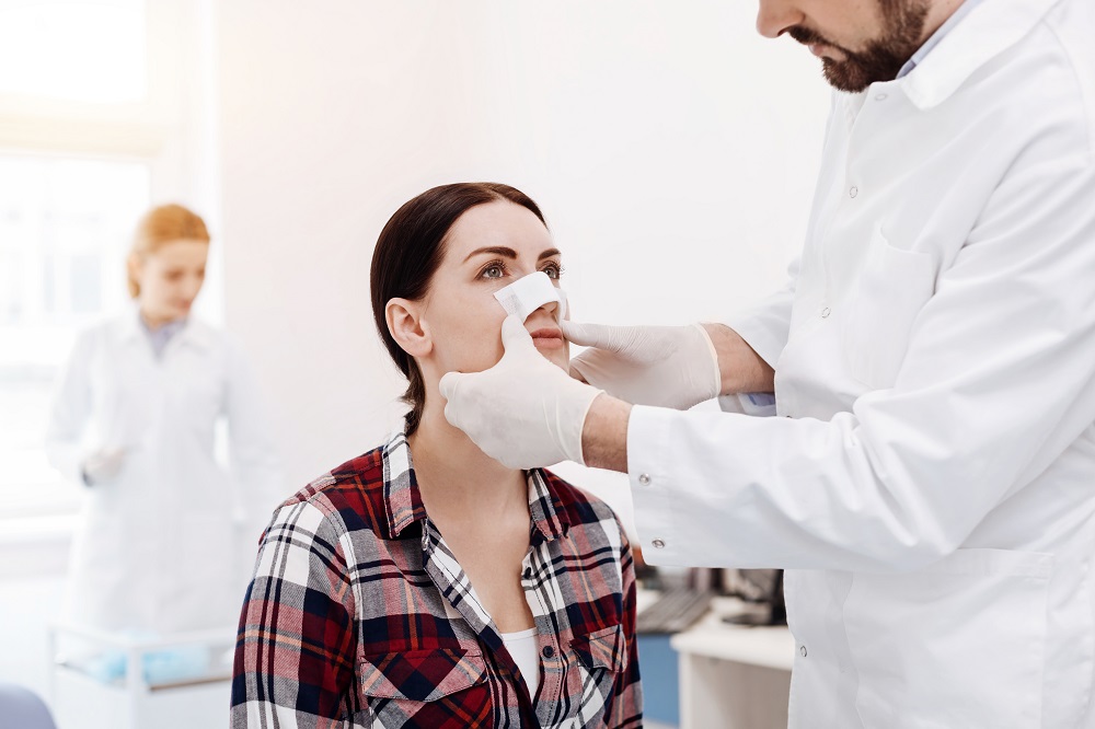 Clínicas recomendadas para rinoplastia: mujer es examinada en postoperatorio.