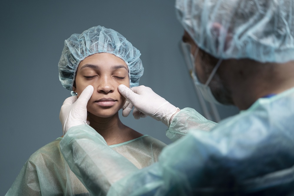 Doctor examina a paciente para Rinoplastia nariz ancha.