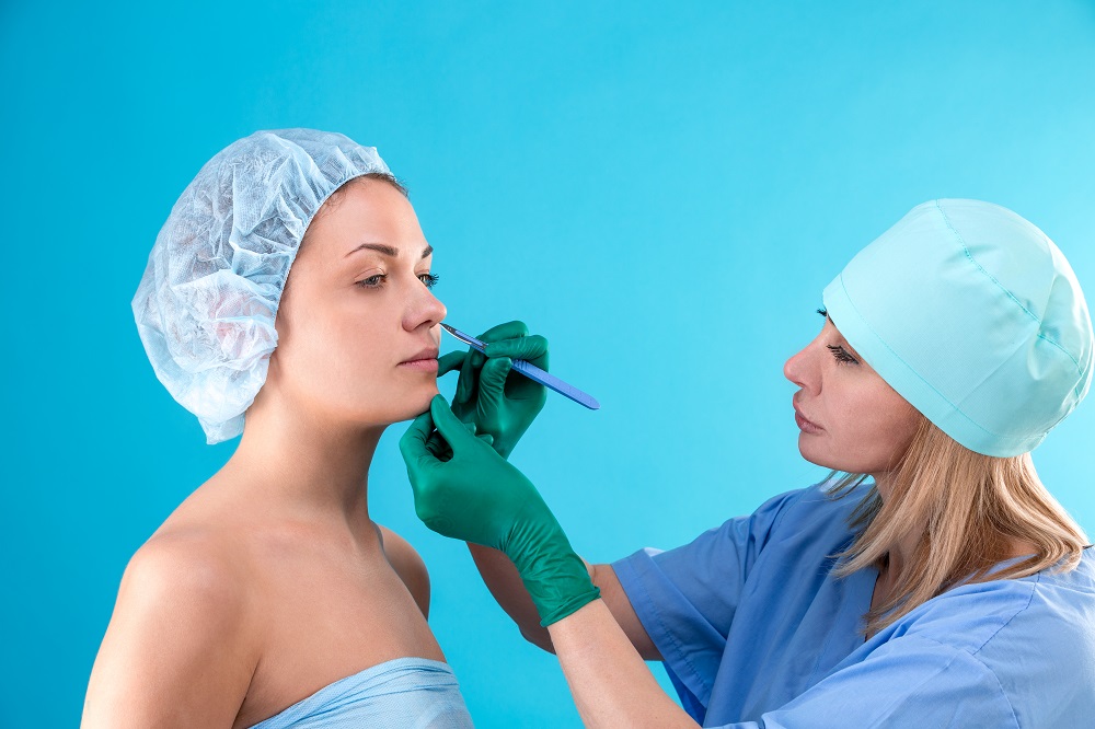 Médica examina nariz para rinoplastia primaria